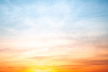 Sunset or sunrise sky with a vibrant gradient of orange, gold, and soft blue. Clear atmosphere with wispy clouds. Peaceful, natural light background. hope, freedom, new day and inspirational Concepts