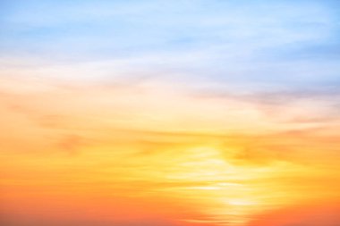 Sunset or sunrise sky with a vibrant gradient of orange, gold, and soft blue. Clear atmosphere with wispy clouds. Peaceful, natural light background. hope, freedom, new day and inspirational Concepts