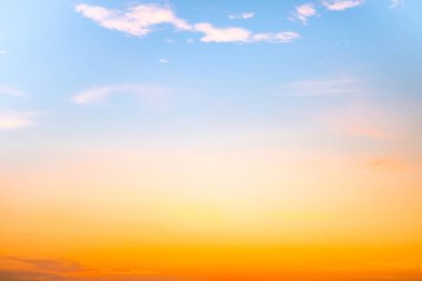 Sunset or sunrise sky with a vibrant gradient of orange, gold, and soft blue. Clear atmosphere with wispy clouds. Peaceful, natural light background. hope, freedom, new day and inspirational Concepts