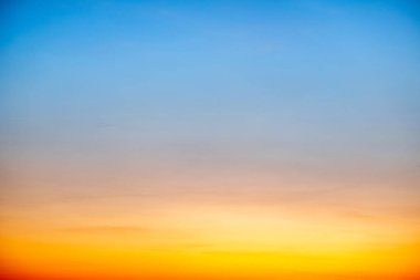 Sunset or sunrise sky with a vibrant gradient of orange, gold, and soft blue. Clear atmosphere with wispy clouds. Peaceful, natural light background. hope, freedom, new day and inspirational Concepts