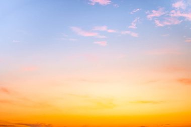 Sunset or sunrise sky with a vibrant gradient of orange, gold, and soft blue. Clear atmosphere with wispy clouds. Peaceful, natural light background. hope, freedom, new day and inspirational Concepts