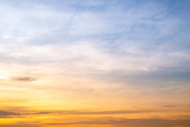 Sunset or sunrise sky with a vibrant gradient of orange, gold, and soft blue. Clear atmosphere with wispy clouds. Peaceful, natural light background. hope, freedom, new day and inspirational Concepts