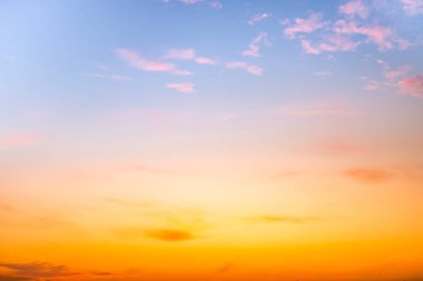 Sunset or sunrise sky with a vibrant gradient of orange, gold, and soft blue. Clear atmosphere with wispy clouds. Peaceful, natural light background. hope, freedom, new day and inspirational Concepts