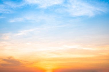 Sunset or sunrise sky with a vibrant gradient of orange, gold, and soft blue. Clear atmosphere with wispy clouds. Peaceful, natural light background. hope, freedom, new day and inspirational Concepts