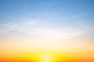 Sunset or sunrise sky with a vibrant gradient of orange, gold, and soft blue. Clear atmosphere with wispy clouds. Peaceful, natural light background. hope, freedom, new day and inspirational Concepts
