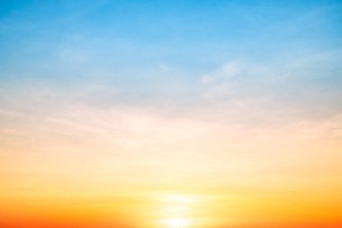 Sunset or sunrise sky with a vibrant gradient of orange, gold, and soft blue. Clear atmosphere with wispy clouds. Peaceful, natural light background. hope, freedom, new day and inspirational Concepts