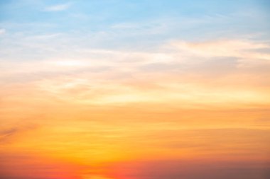 Sunset or sunrise sky with a vibrant gradient of orange, gold, and soft blue. Clear atmosphere with wispy clouds. Peaceful, natural light background. hope, freedom, new day and inspirational Concepts