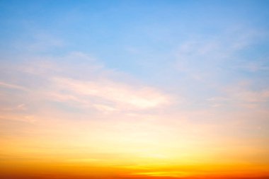 Sunset or sunrise sky with a vibrant gradient of orange, gold, and soft blue. Clear atmosphere with wispy clouds. Peaceful, natural light background. hope, freedom, new day and inspirational Concepts