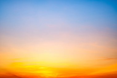 Sunset or sunrise sky with a vibrant gradient of orange, gold, and soft blue. Clear atmosphere with wispy clouds. Peaceful, natural light background. hope, freedom, new day and inspirational Concepts