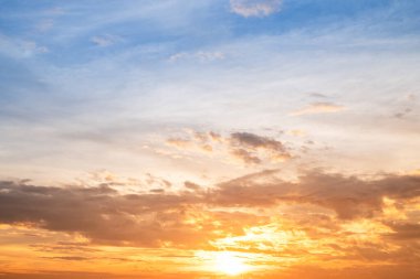Sunset or sunrise sky with a vibrant gradient of orange, gold, and soft blue. Clear atmosphere with wispy clouds. Peaceful, natural light background. hope, freedom, new day and inspirational Concepts