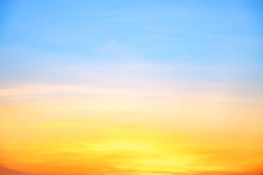 Sunset or sunrise sky with a vibrant gradient of orange, gold, and soft blue. Clear atmosphere with wispy clouds. Peaceful, natural light background. hope, freedom, new day and inspirational Concepts