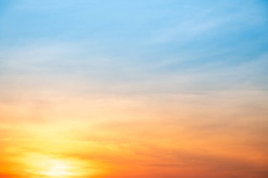 Sunset or sunrise sky with a vibrant gradient of orange, gold, and soft blue. Clear atmosphere with wispy clouds. Peaceful, natural light background. hope, freedom, new day and inspirational Concepts