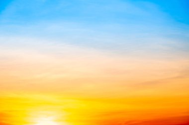 Sunset or sunrise sky with a vibrant gradient of orange, gold, and soft blue. Clear atmosphere with wispy clouds. Peaceful, natural light background. hope, freedom, new day and inspirational Concepts