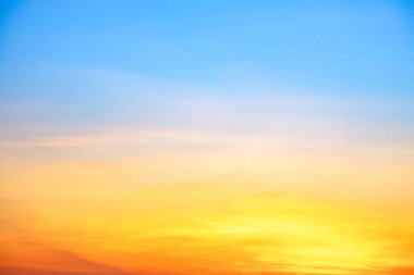 Sunset or sunrise sky with a vibrant gradient of orange, gold, and soft blue. Clear atmosphere with wispy clouds. Peaceful, natural light background. hope, freedom, new day and inspirational Concepts
