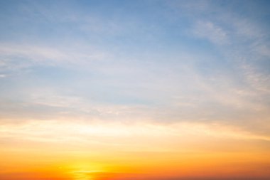 Sunset or sunrise sky with a vibrant gradient of orange, gold, and soft blue. Clear atmosphere with wispy clouds. Peaceful, natural light background. hope, freedom, new day and inspirational Concepts