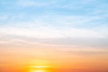 Sunset or sunrise sky with a vibrant gradient of orange, gold, and soft blue. Clear atmosphere with wispy clouds. Peaceful, natural light background. hope, freedom, new day and inspirational Concepts