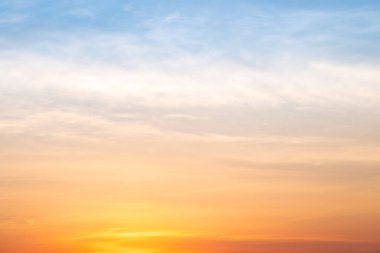 Sunset or sunrise sky with a vibrant gradient of orange, gold, and soft blue. Clear atmosphere with wispy clouds. Peaceful, natural light background. hope, freedom, new day and inspirational Concepts