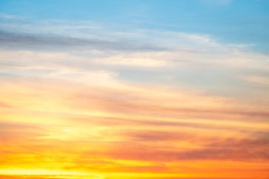 Sunset or sunrise sky with a vibrant gradient of orange, gold, and soft blue. Clear atmosphere with wispy clouds. Peaceful, natural light background. hope, freedom, new day and inspirational Concepts
