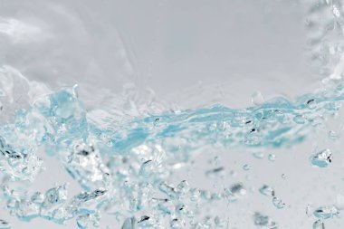 Dalgalı şeffaf mavi berrak su yüzeyi dokusu. Yüzey mavi lekeler ve kabarcıklar güneş ışığıyla yansıyan su dalgaları.