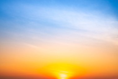 Sunset or sunrise sky with a vibrant gradient of orange, gold, and soft blue. Clear atmosphere with wispy clouds. Peaceful, natural light background. hope, freedom, new day and inspirational Concepts