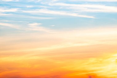 Sunset or sunrise sky with a vibrant gradient of orange, gold, and soft blue. Clear atmosphere with wispy clouds. Peaceful, natural light background. hope, freedom, new day and inspirational Concepts