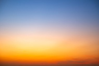 Sunset or sunrise sky with a vibrant gradient of orange, gold, and soft blue. Clear atmosphere with wispy clouds. Peaceful, natural light background. hope, freedom, new day and inspirational Concepts