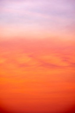 Canlı turuncu ve altın renkleri ve yumuşak mavi, ince bulutlu berrak atmosferi olan güzel bir gündoğumu gökyüzü. Huzurlu, arkaplan ve kopyalama alanı için mükemmel, Yüksek çözünürlüklü resimler dikey