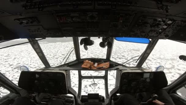 Uitzicht op de cabine van de mi-8 helikopter. Russische helikopter vliegt over stukken ijs in de sneeuw. Hand van de piloten aan het roer van de helikopter. De helikopter vliegt over zee met ijs.. — Stockvideo