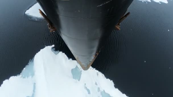 La proue du navire vole au-dessus de l'eau avec de la glace. Des morceaux de glace sur la fissure. La proue noire du vaisseau avec de la rouille. Ancres suspendues sur les côtés — Video