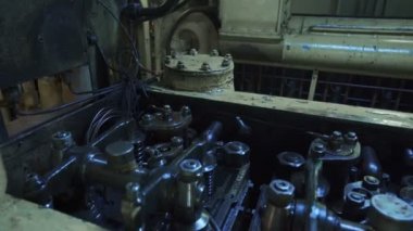 Eski dizel motor çalışıyor. Motor vanaları çalışıyor. Petrol mekanizması. Gaz dağıtım mekanizması çalışıyor. Gemide dizel motor var. Gemideki makine dairesi.