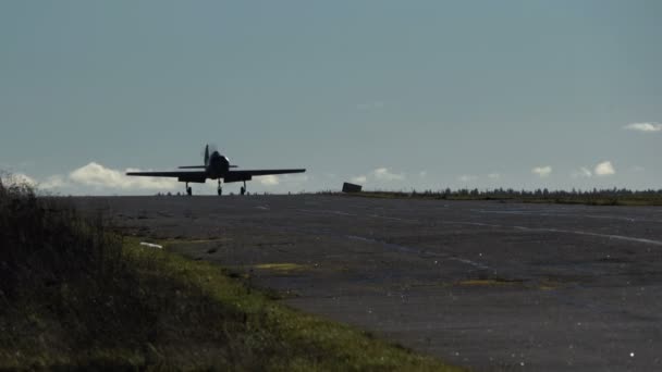 Aerobatic aircraft rides on the runway. O Yak-52 vem em direcção a uma silhueta na pista.. — Vídeo de Stock