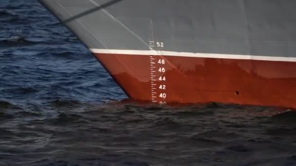 Τόξο του πλοίου στο νερό με κλίμακα μέτρησης. Στο βάθος, τα πλοία με τους ανθρώπους περνούν στην θολούρα — Αρχείο Βίντεο