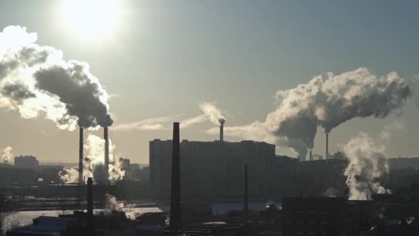 Smoke from chimneys in city. Residential buildings, river. Lots of pipes. The sun. Industrial area — Stock Video
