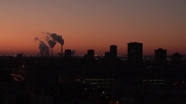 Rök från skorstenar bakom kvällsstaden. Termiskt kraftverk. Bostadsbyggnader. Röd himmel. — Stockvideo