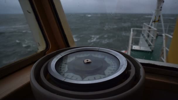 Compass on the ship. Storm. Close-up. Splashes of waves on the glass. View of the bow and the sea from behind the compass. — Stock Video