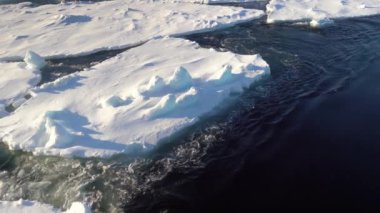 Ice floats. Pieces of ice move. Gulls fly. The Arctic. . Ice is melting. Blue Ice. Water boil