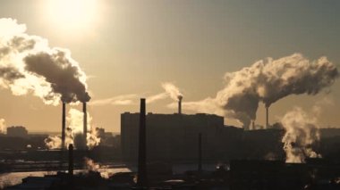 White smoke from chimneys. Smoke from pipes in city. Winter. Pipes among the houses