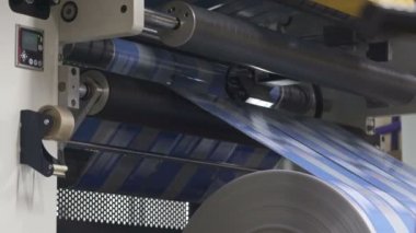 Flexo baskı. Matbaa. Şaft hızla dönüyor. Film şaftlarda döner. Rroller makinesinin izleri. Anilox şaftları