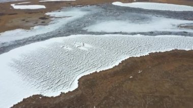 Kar ve tarlalarda göl üzerinde uçuyor. Hava görüntüsü. - Beyaz. Donmuş beyaz göl. Sarı tarlanın etrafında. Yatak tonları. Manzara. Donmuş bir göldeki doku. Sarı.