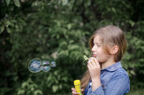 Portret van schattige mooie meisje zeepbellen blazen. — Stockfoto