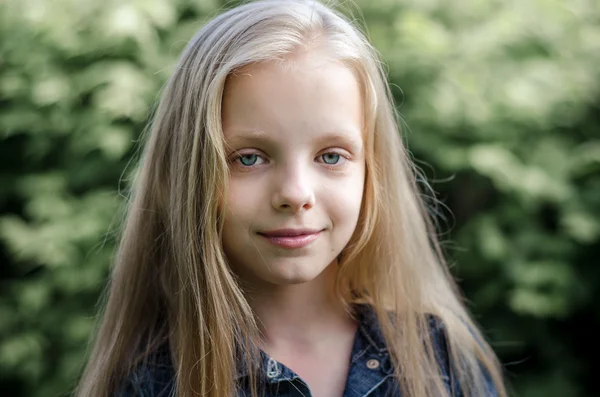 Porträtt av en vacker blond liten flicka med långt hår. — Stockfoto