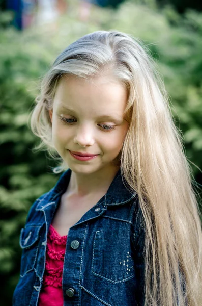 Retrato de una hermosa niña rubia con el pelo largo . —  Fotos de Stock