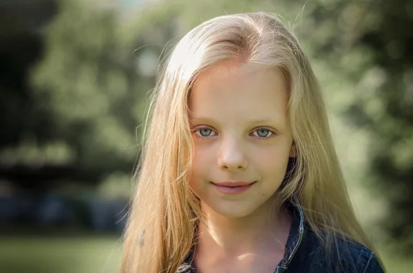 Retrato de una hermosa niña rubia con el pelo largo . —  Fotos de Stock