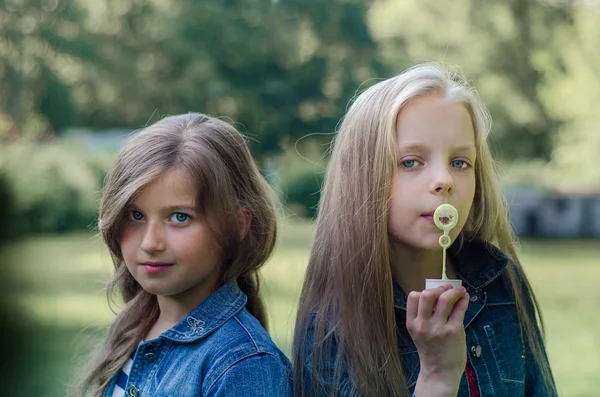 Retrato de dos niñas lindas disfrutando del verano al aire libre . —  Fotos de Stock