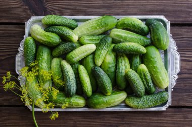 Bir tepsi ahşap arka plan üzerinde salatalık.