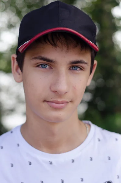 Close-up van portret van een schattige tiener in een baseballcap. — Stockfoto