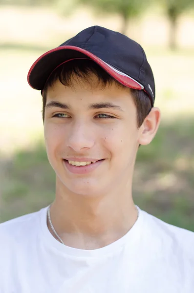 Close-up van portret van een schattige tiener in een baseballcap. — Stockfoto