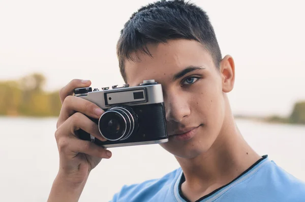 Roztomilý chlapec teenager s vintage dálkoměrný fotoaparát. — Stock fotografie