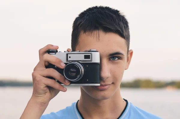 Roztomilý chlapec teenager s vintage dálkoměrný fotoaparát. — Stock fotografie