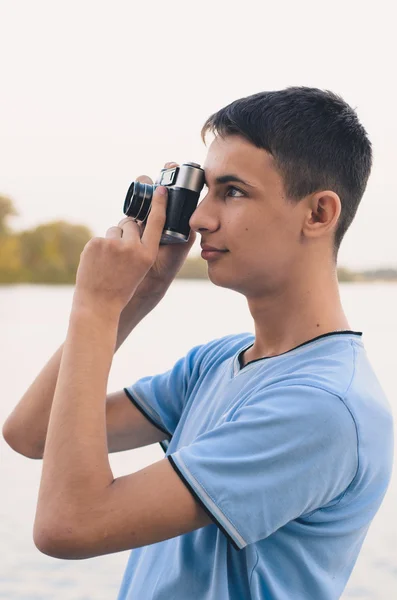 Leuke jongen tiener met vintage meetzoeker camera. — Stockfoto